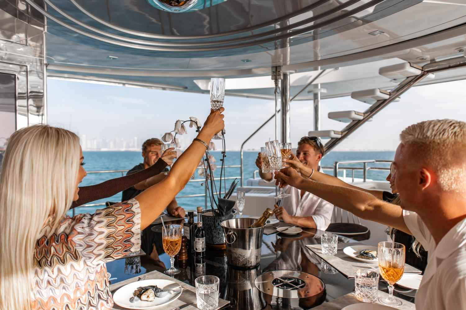 Friends raising their glasses to celebrate a birthday on a yacht in Dubai