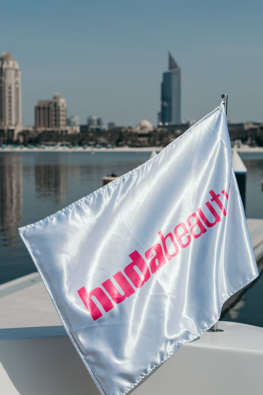 A yacht branded for a beauty brand with flags on deck in Dubai