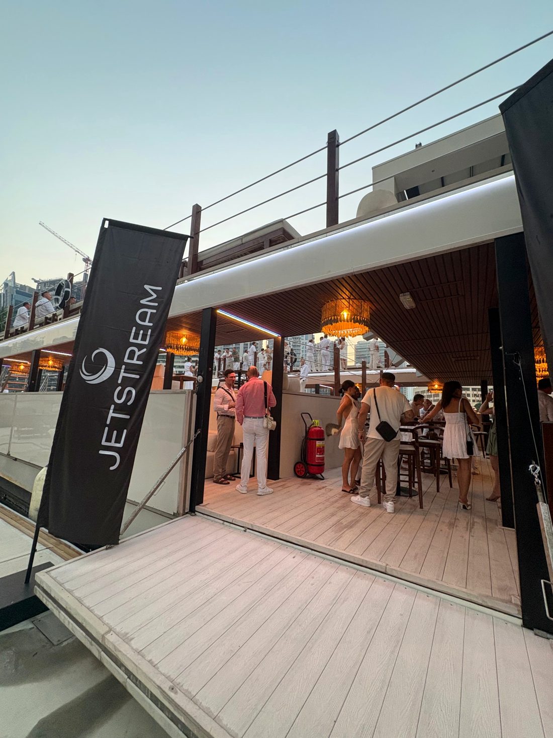 Guests arriving on board the houseboat past a Jetstream banner
