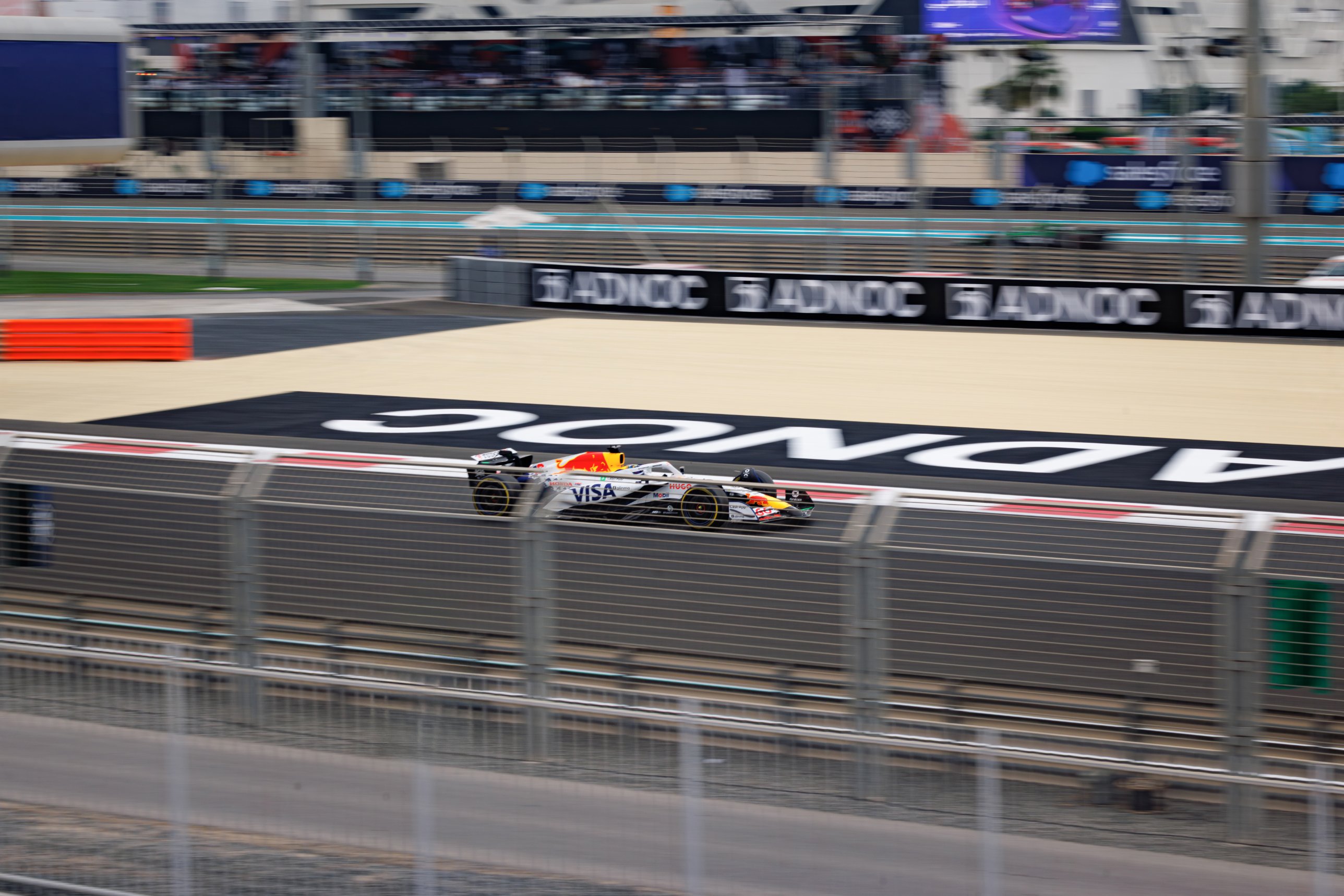 A Formula 1 car at speed seen from a yacht at Yas Marina