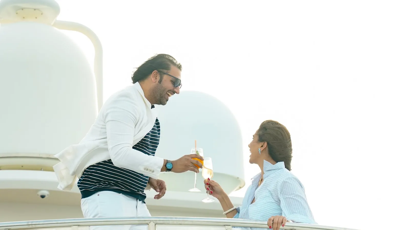 Couple toasting with champagne on the flybridge of a superyacht in Dubai