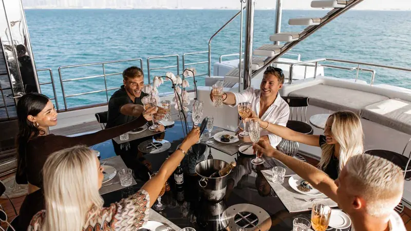Friends toasting on the deck of a yacht in Dubai