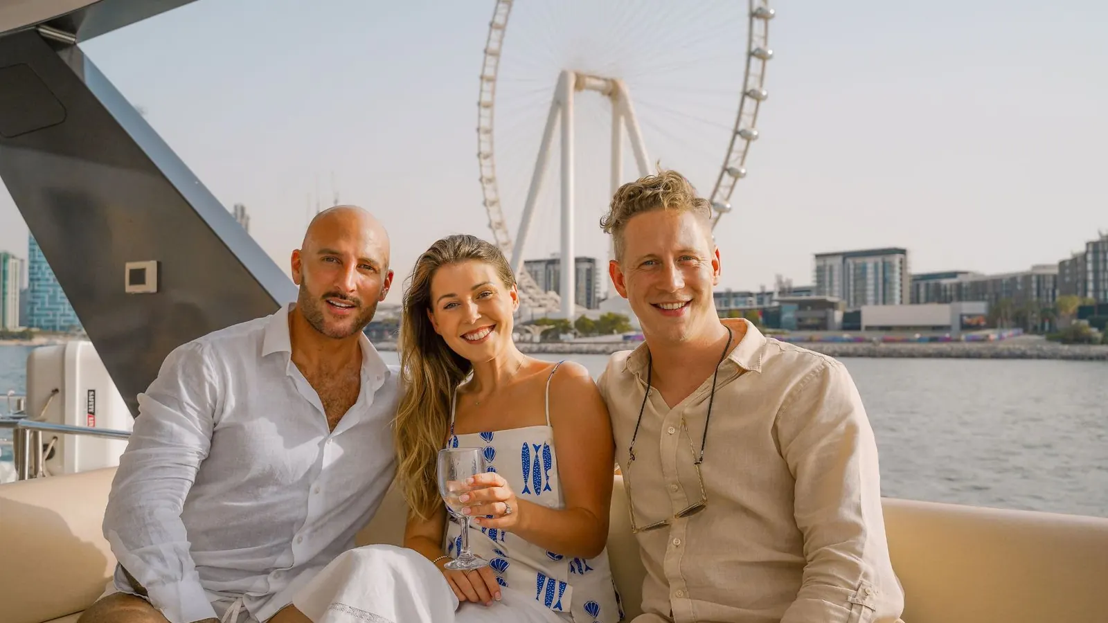 Friends toasting with Champagne on the deck of a private yacht in Dubai at sunset