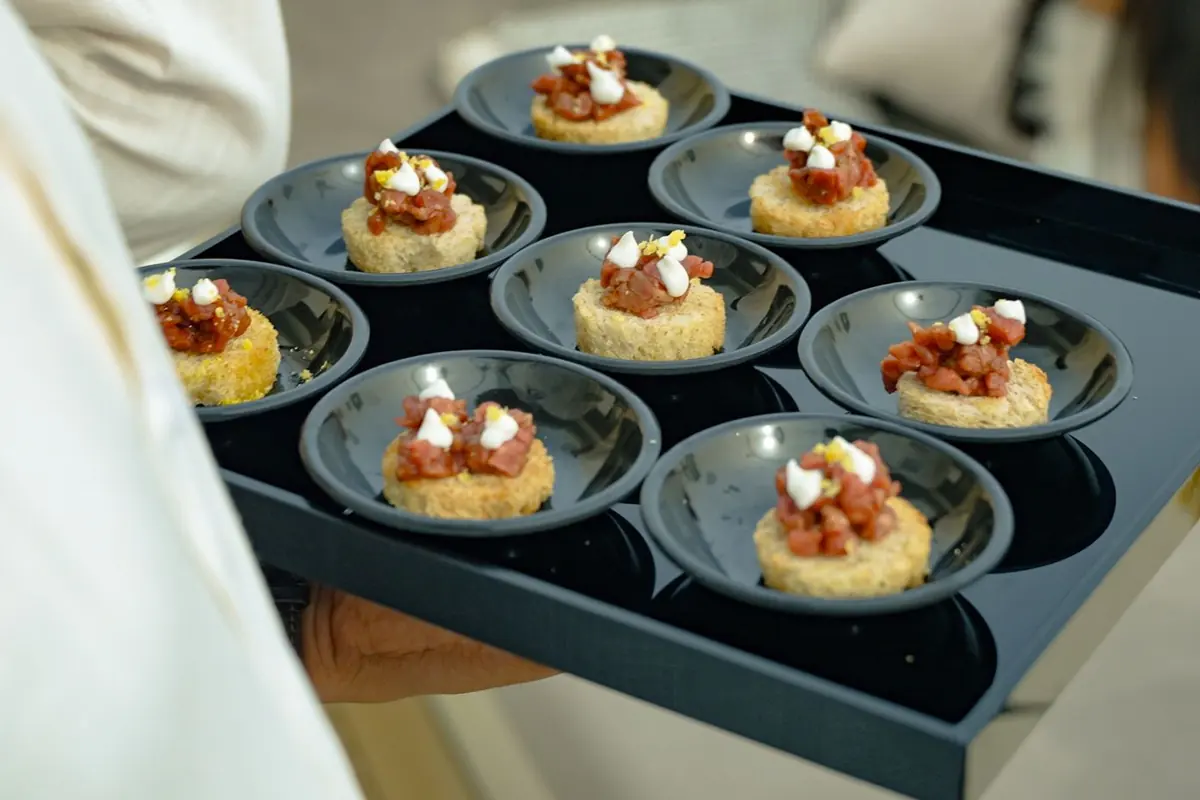 Canapés served on a black tray on board a yacht