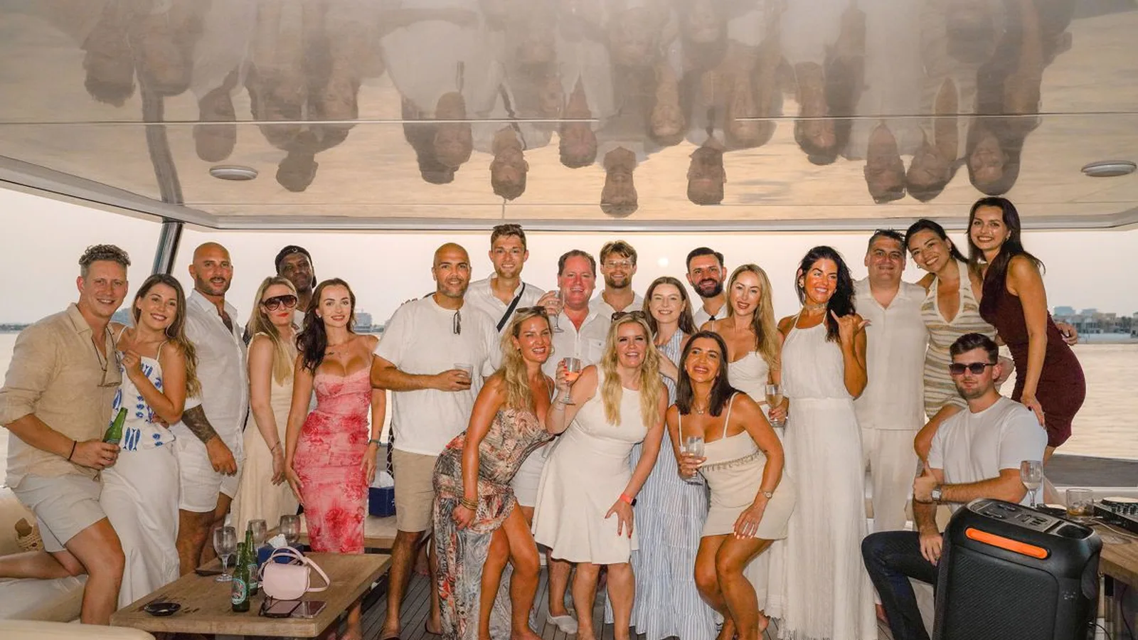 Forty guests together on the aft deck of a private yacht at sunset in Dubai
