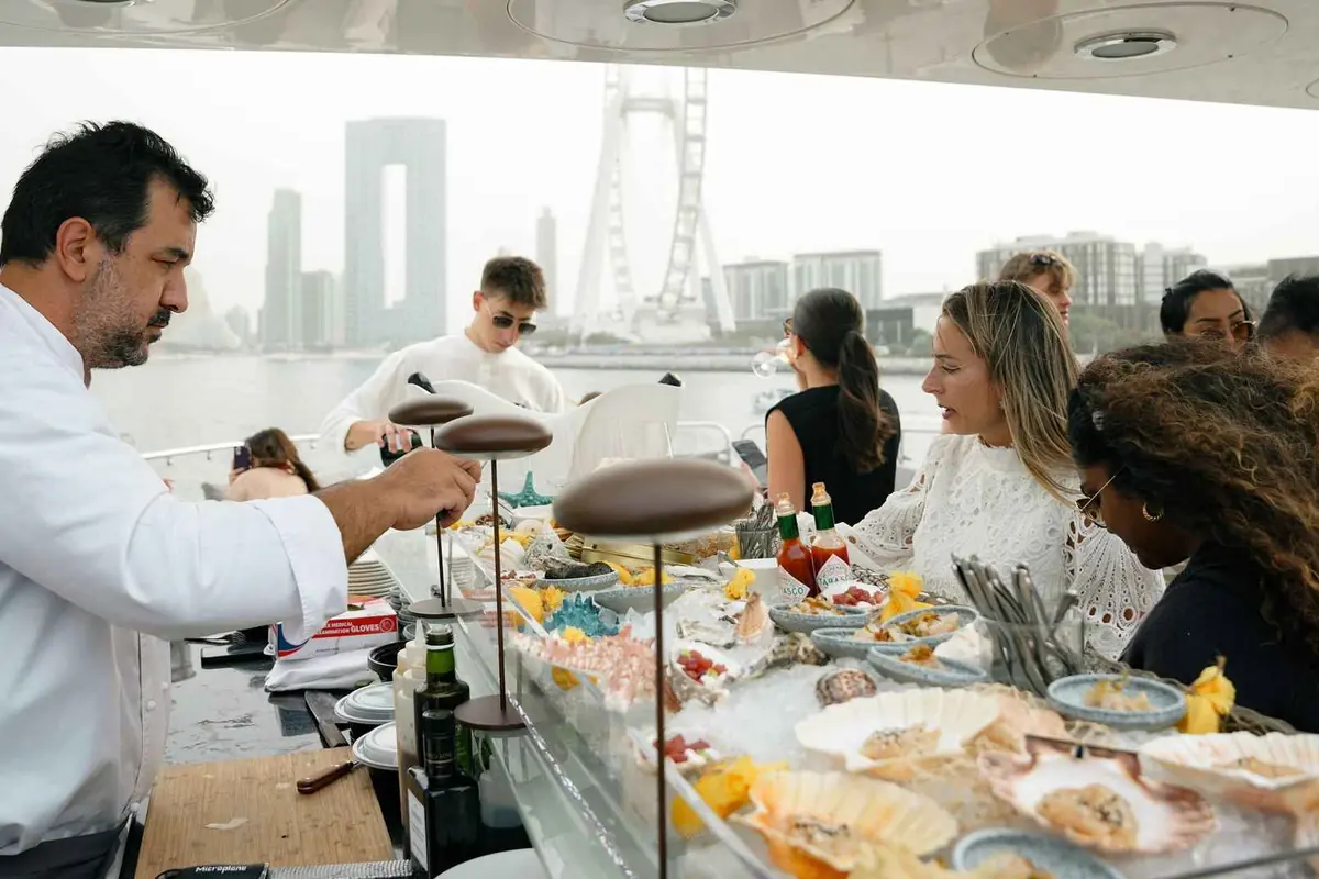 Chef serving fresh seafood to guests on a private yacht in Dubai
